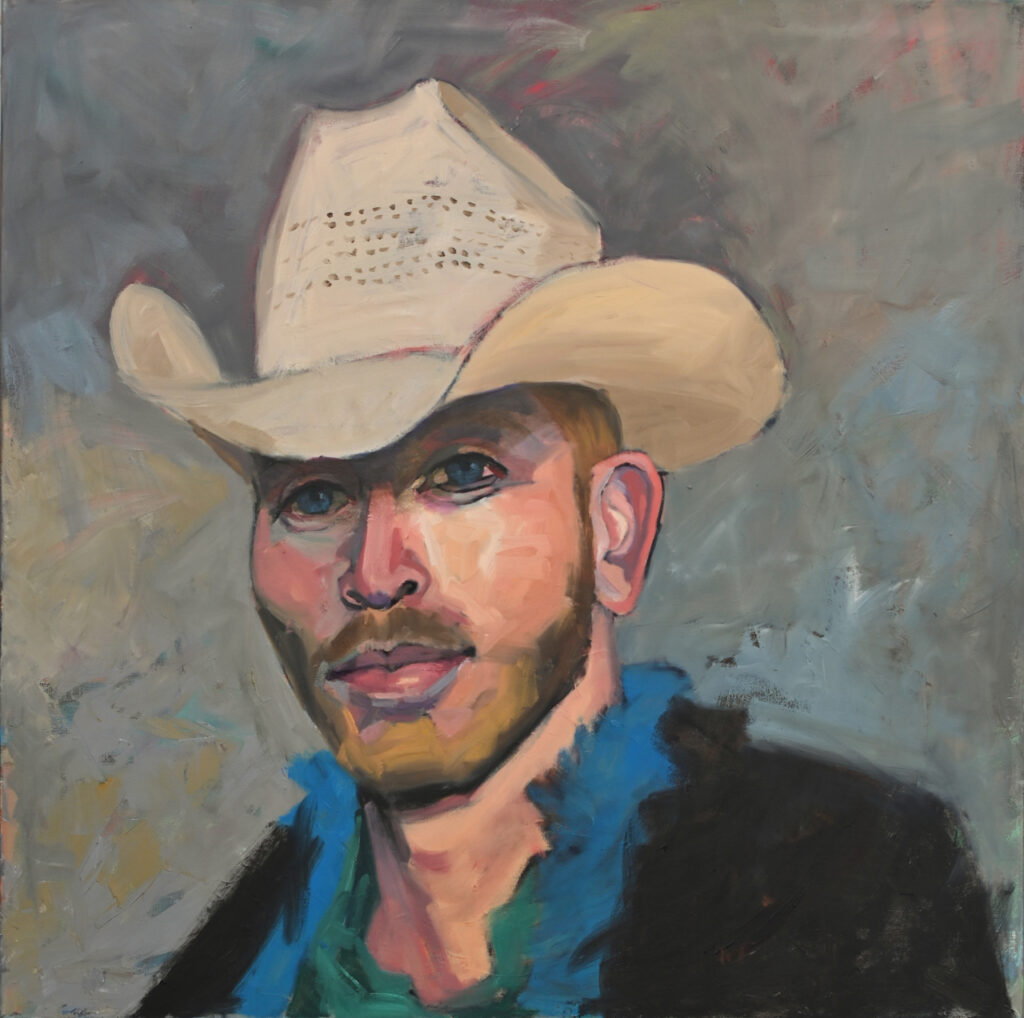 Man with a blonde beard wearing a white cowboy hat and a blue scarf