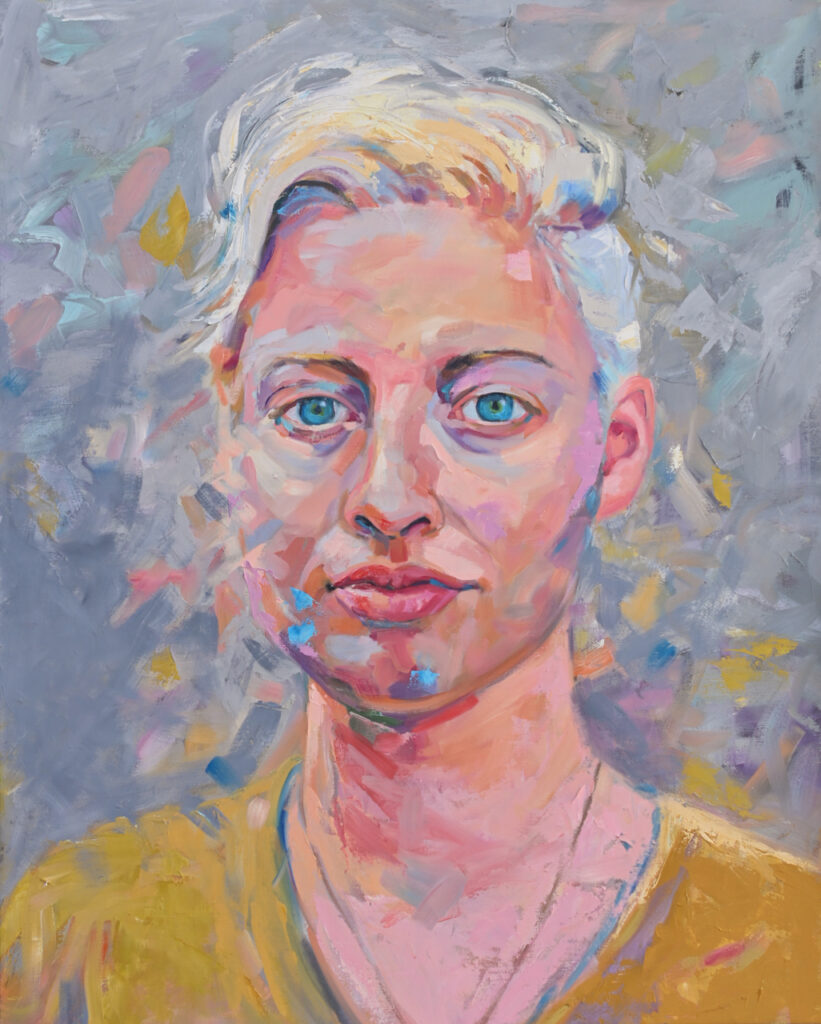 Portrait of a person with short platinum blonde hair and bright blue eyes.