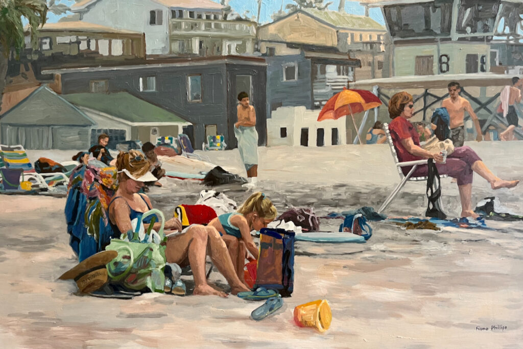 An original oil painting on board in contemporary realist style of a beach scene with families and beach umbrellas with beach homes and a life guard station