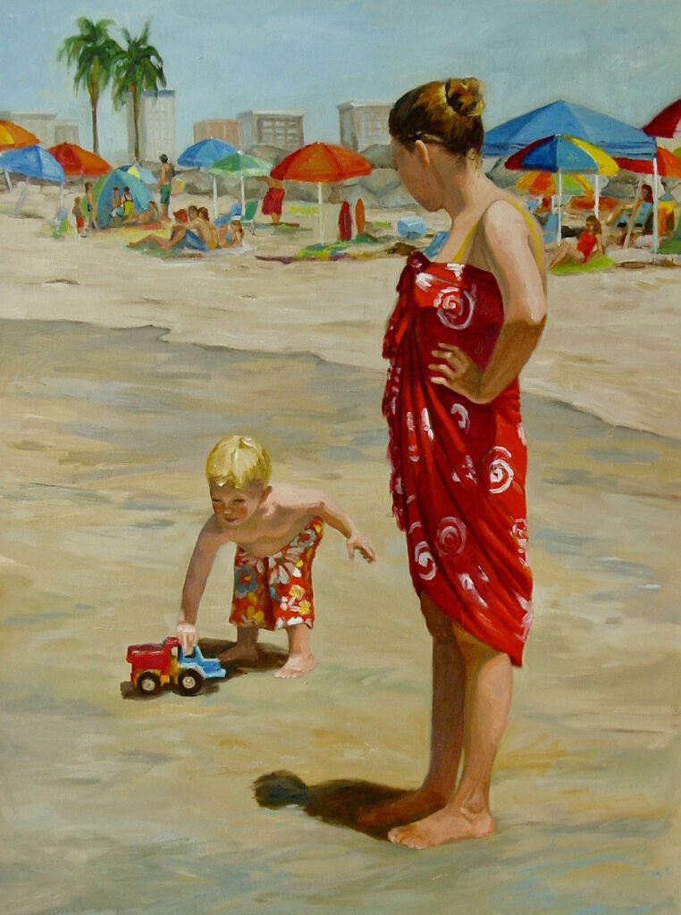 Mother and little boy at the beach. The woman is wearting a red parea